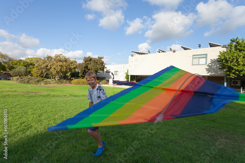 Happy child running with a rainbow kite