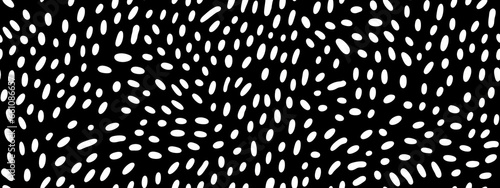 Seamless small dense polkadot animal spots pattern in white on black background. Abstract aboriginal dot art motif or organic cellular texture in a trendy doodle line art or linocut style