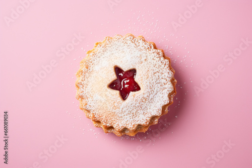 Single traditional Linzer Christmas cookie with shortcrust pastry and jam filling on pink background photo