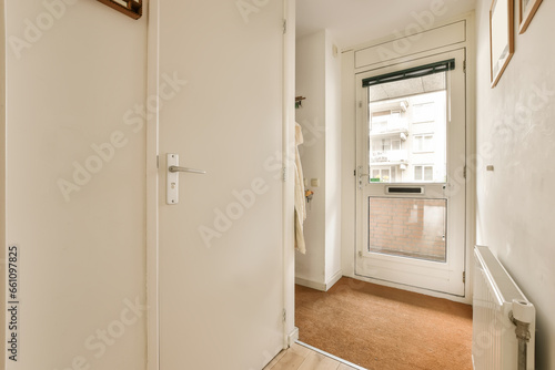 an empty room with white walls and wood trim on the door  there is a small window in the corner