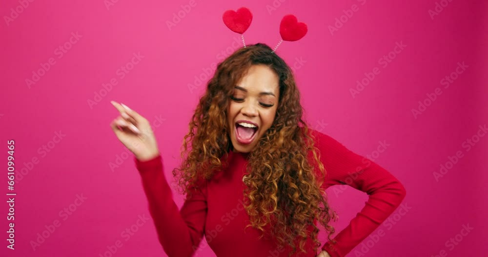 Happy young woman dancing and grooving on Valentine's Day, pink studio Happy young woman dancing and grooving on Valentine's Day, pink studio