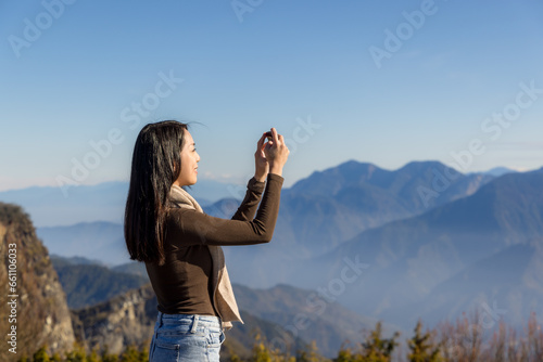 Hike woman use cellphone to take photo over the mountain