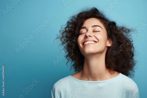 cheerful young beautiful and stylish female model posing against blue background © Uzair