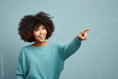 Radiant Joy: A Young African American Woman Pointing and Smiling Upward, Exuding Vibrant Positivity