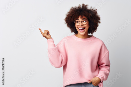 Young African American Woman in Glasses, Pointing Up, Pink Sweater, white background