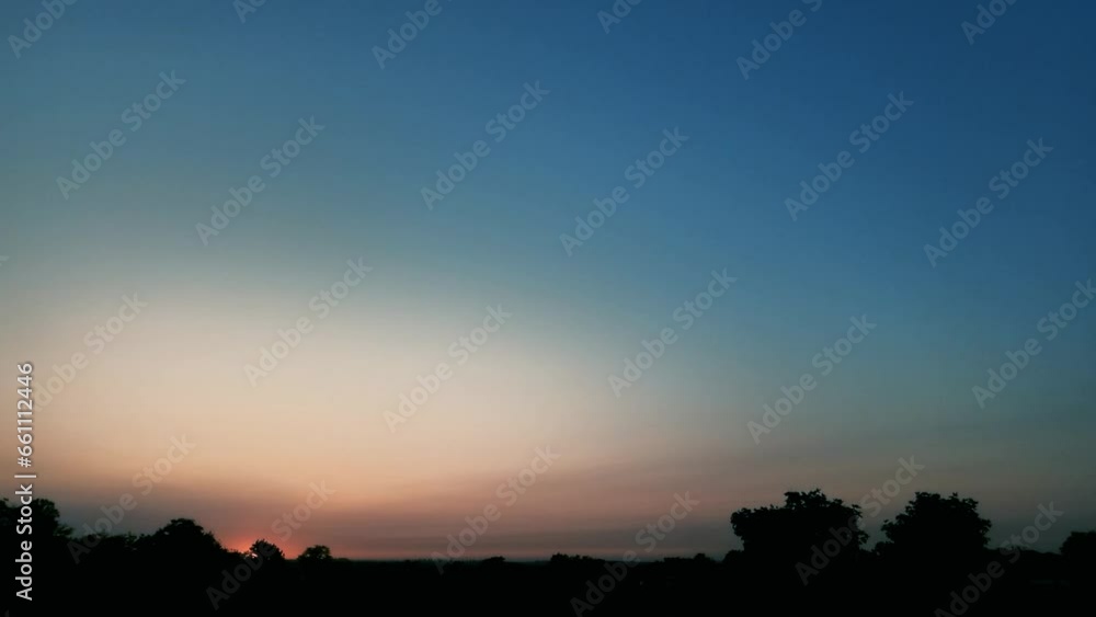 Sunrise time-lapse of the horizon with silhouettes of trees from behind which the morning sun comes out. Sunrise time-lapse of the horizon with silhouettes of trees from behind which the morning sun comes out.
