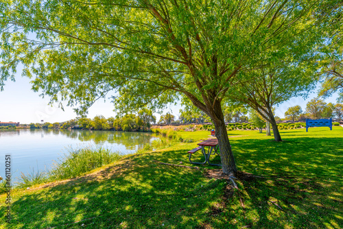 A shady tree covered picnic area at the public Blue Heron Park and Fishing Pier along the shores of Moses Lake in the Central Washington city of Moses Lake  Washington USA.