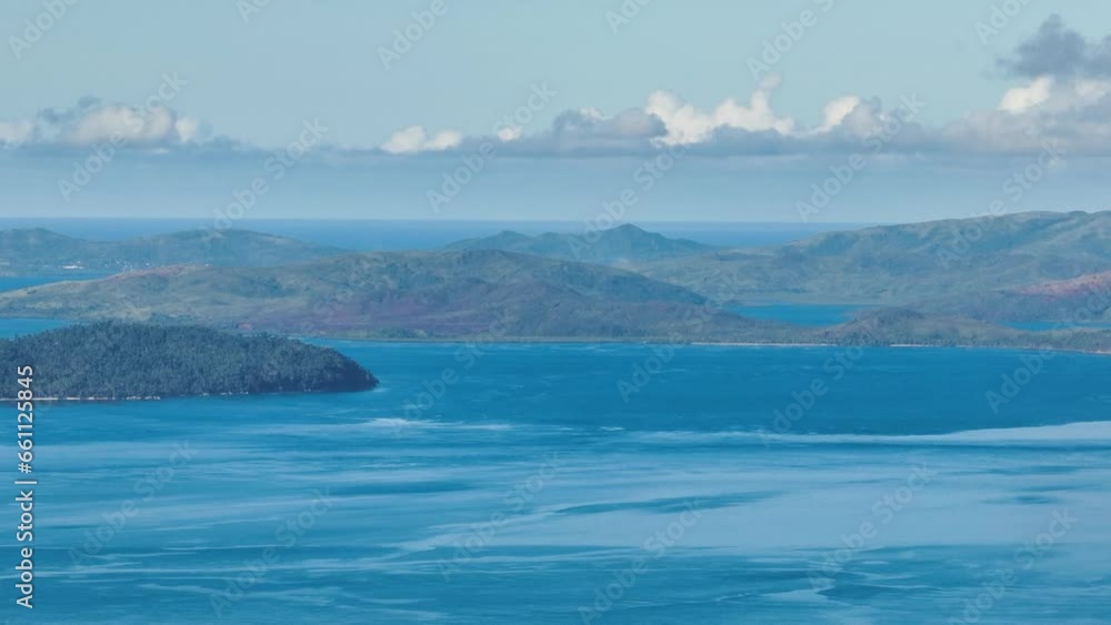 Blue sea and tropical island under blue sky and cloud. Mindanao, Philippines. Zoom view. Blue sea and tropical island under blue sky and cloud. Mindanao, Philippines. Zoom view.