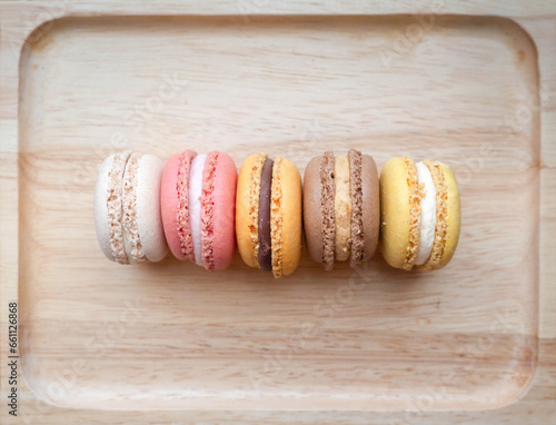 Top view of homemade colorful macarons on a wooden tray