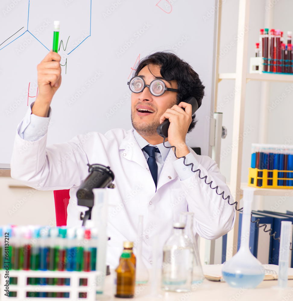 Young funny chemist in front of white board Young funny chemist in front of white board