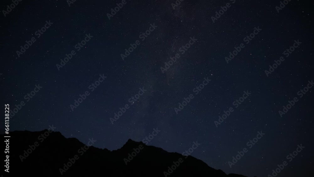 The Milky Way galaxy moving over the mountain range on a background. The Milky Way galaxy moving over the mountain range on a background.