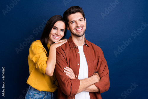 Portrait of two peaceful cheerful partners toothy smile embrace crossed arms empty space isolated on blue color background