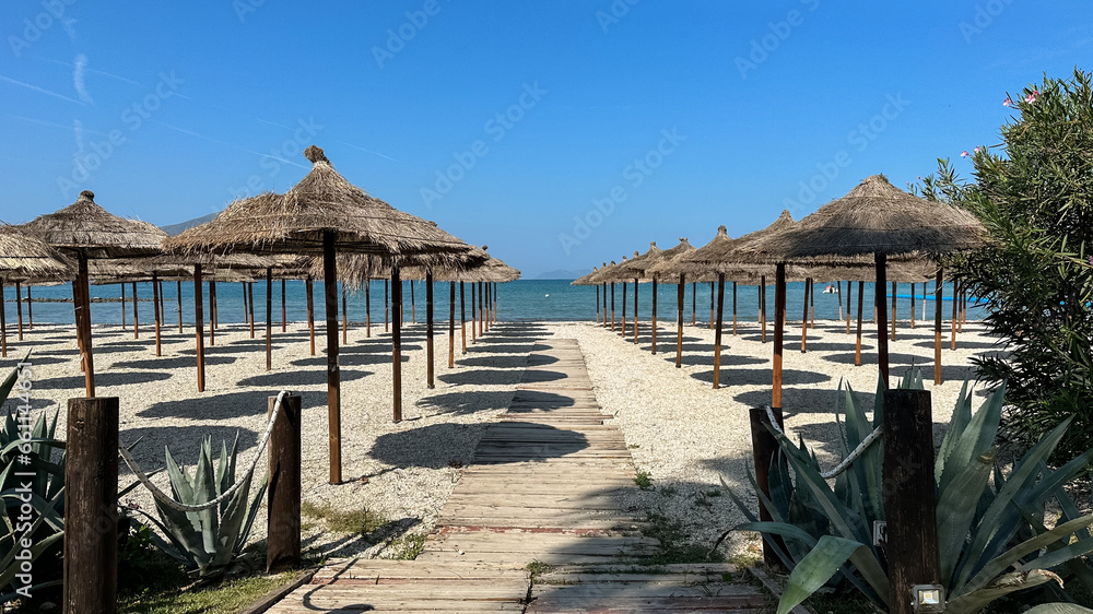 Fototapeta premium straw beach umbrellas in rows on the beach