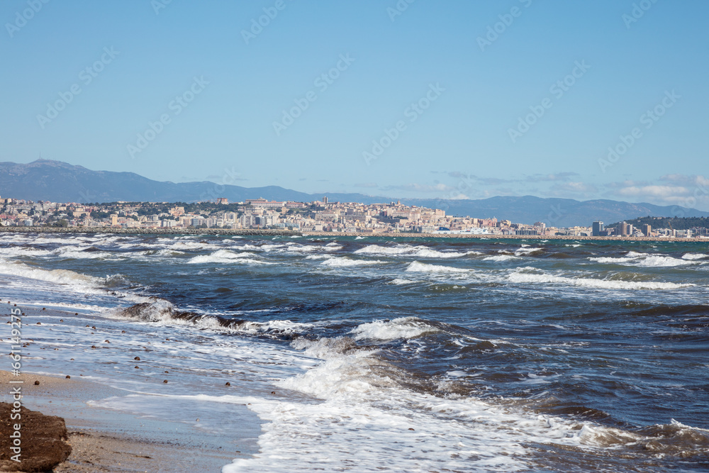rough sea waves, in the background city of Sant'Antioco, Sardinia, Italy