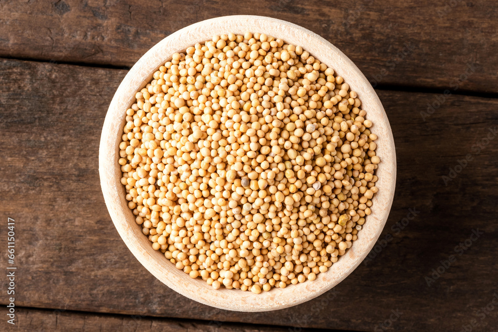 White mustard seeds in bowl on wooden table. Close up. Top view White mustard seeds in bowl on wooden table. Close up. Top view