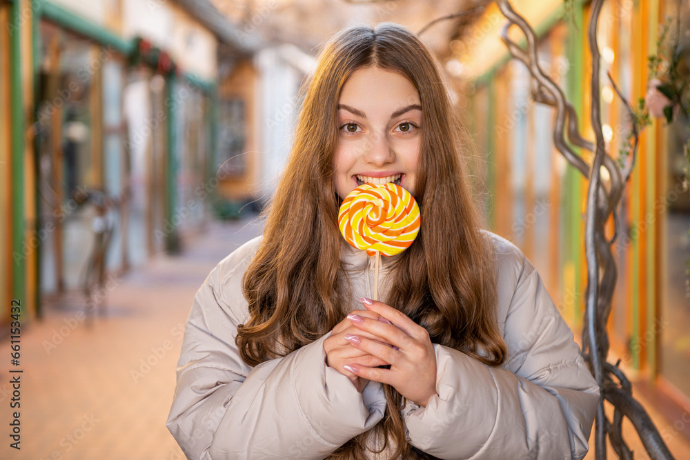 girl eating lollipop candy outdoor. girl with lollipop candy with long hair.
