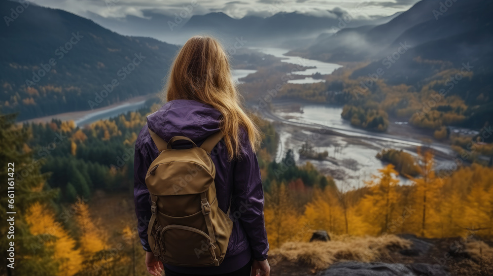 Rear view, A girl in a jacket standing on a mountain, View of the mountains and an autumn forest.