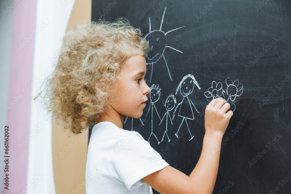 Little girl draws a family on a chalkboard Little girl draws a family on a chalkboard