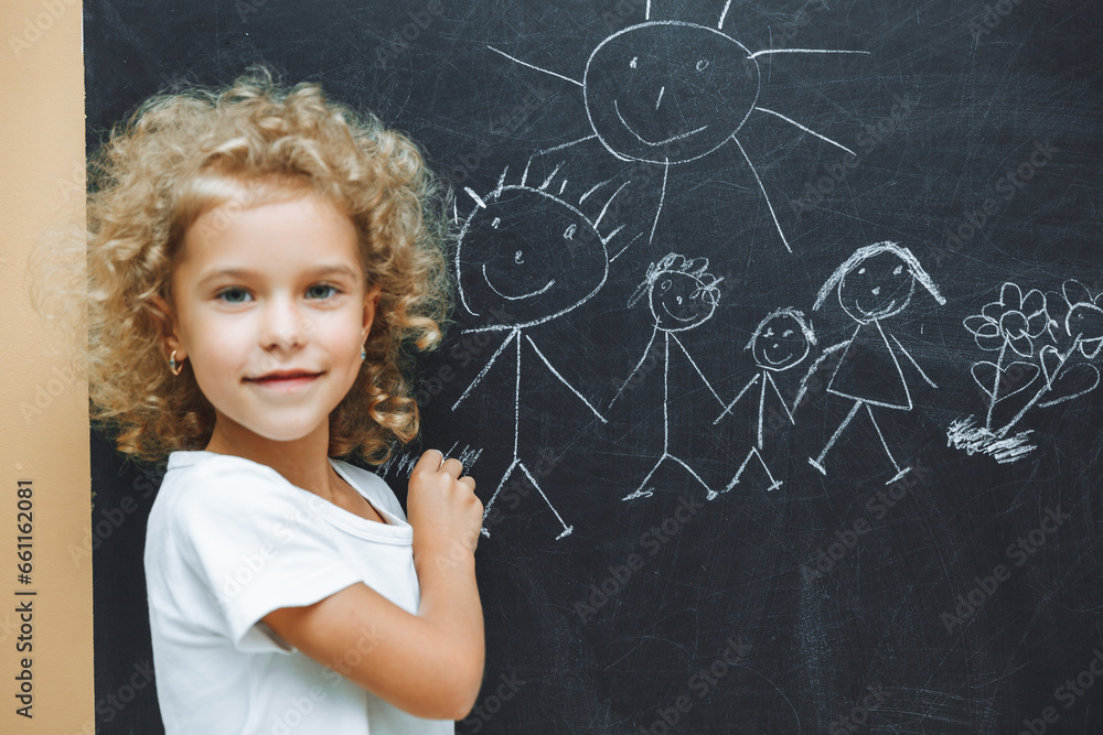 Little girl draws a family on a chalkboard Little girl draws a family on a chalkboard