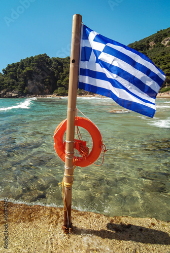 Greek flag with life belt, Ionian seashore near Sinarades town on Corfu Island, Greece photo