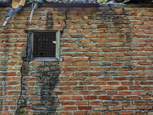 An aged concrete building with brickwork walls and window structures.