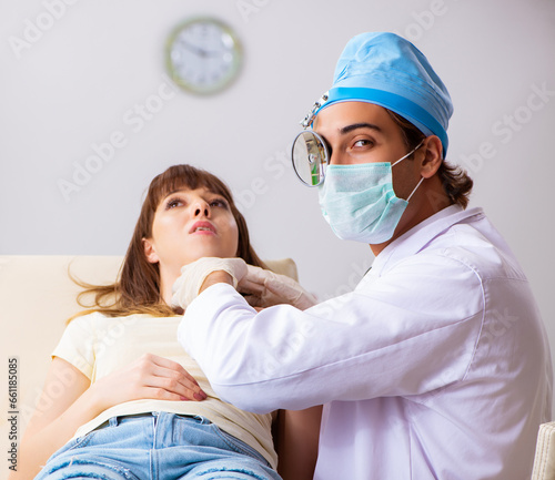 Young woman visting male doctor otolaryngologist photo
