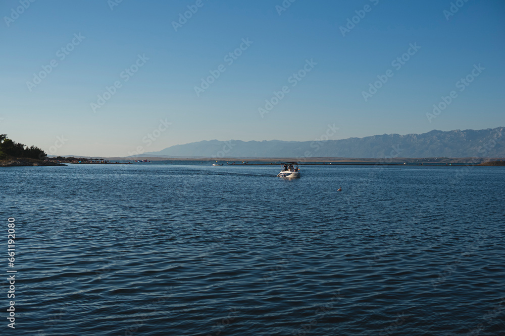 landscape with a boat on the adriatic sea with velebit mountains on the background