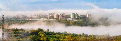 Autumn city panorama with housing estate, buildings and trees covered in morning clouds. View of the city of Brno, Czech Republic.