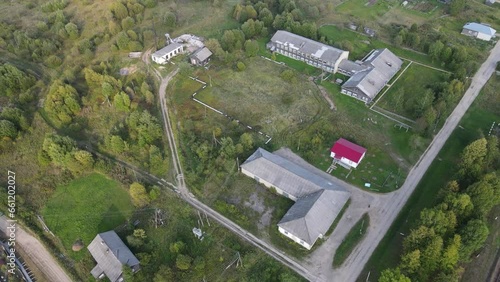 Aged buildings surrounded by green trees and fields in ancient disrict in Russia photo