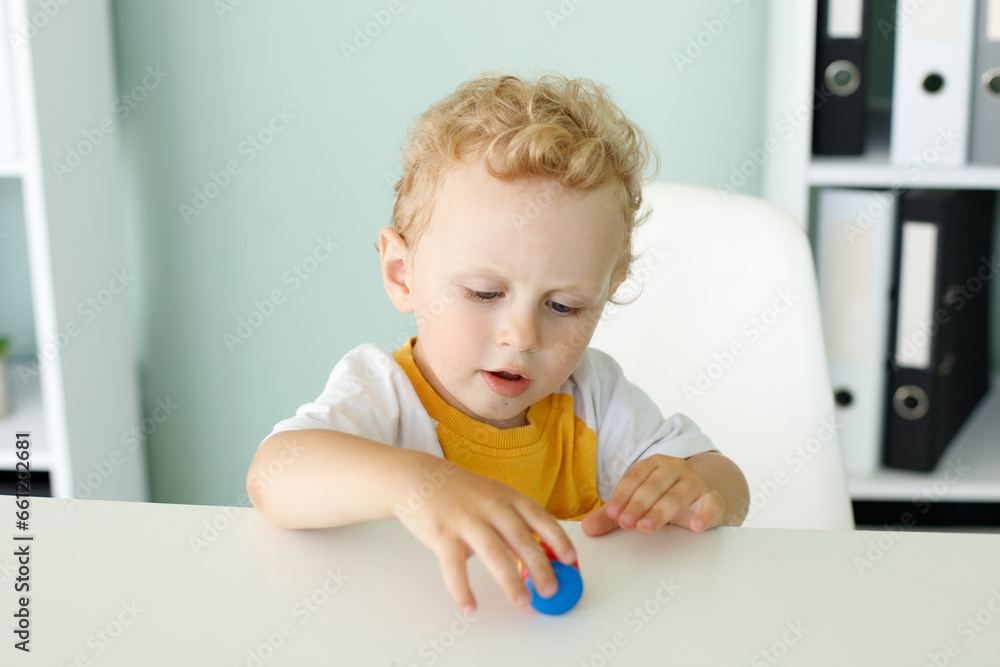 portrait of a cute blond boy playing at the table portrait of a cute blond boy playing at the table