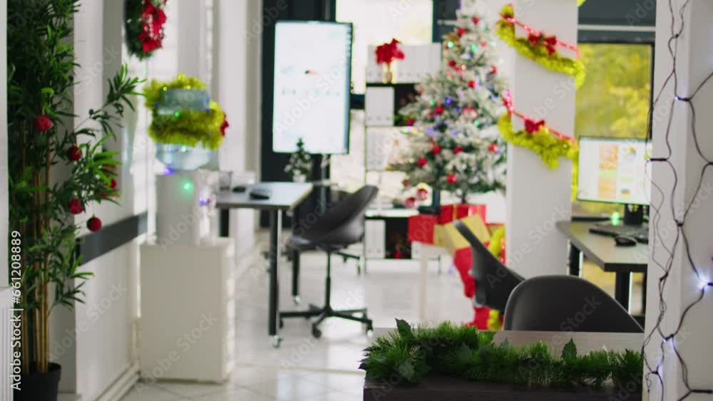 Tilt up shot of empty festive ornate modern office workspace with beautiful Christmas tree and lights. Xmas adorn workplace ready for festivities before winter holiday season vacation Tilt up shot of empty festive ornate modern office workspace with beautiful Christmas tree and lights. Xmas adorn workplace ready for festivities before winter holiday season vacation