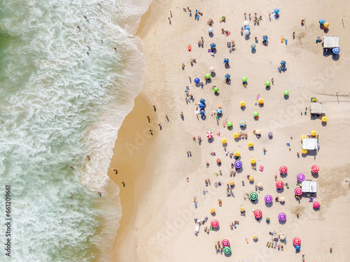 Top down aerial view of people relaxing and enjoying summer at Ipanema Beach in Rio de Janeiro, Brazil. 