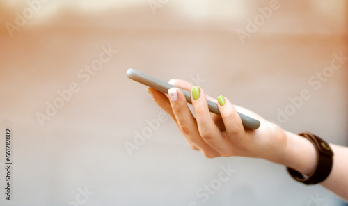 Girl is holding a smartphone in her hands closeup view.