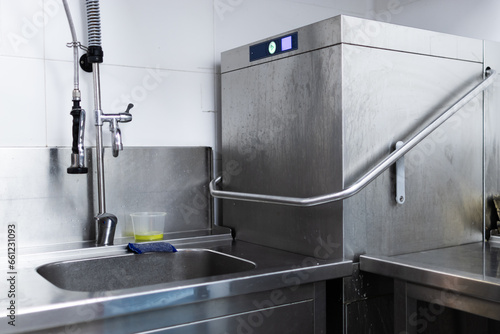 Industrial dishwasher in a restaurant kitchen washing dishes