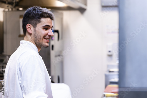 Young Caucasian boy is happy in the kitchen of his work.