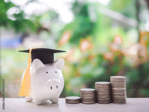 Piggy bank with graduation hat and stack of coins. The concept of saving money for education, student loan, scholarship, tuition fees in future