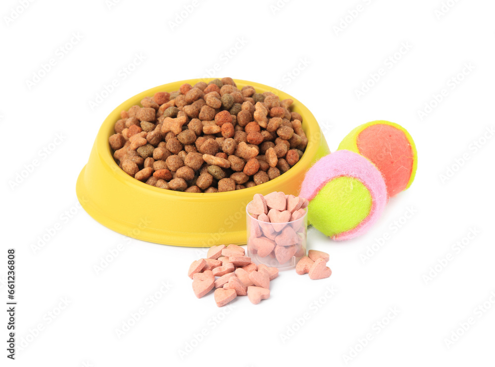 Dry pet food in bowl, vitamins and toys isolated on white Dry pet food in bowl, vitamins and toys isolated on white