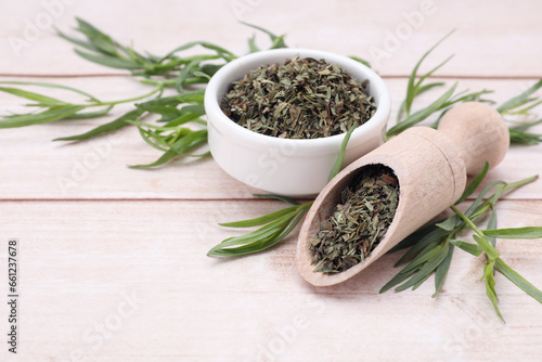 Dry and fresh tarragon on wooden table  space for text