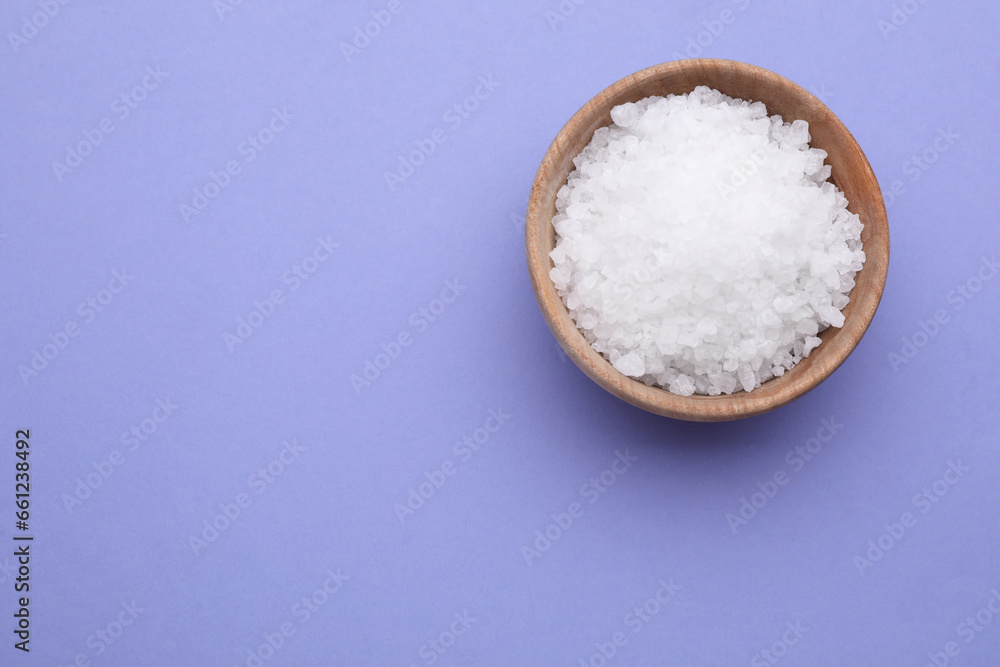 Bowl of sea salt on violet background, top view. Space for text Bowl of sea salt on violet background, top view. Space for text