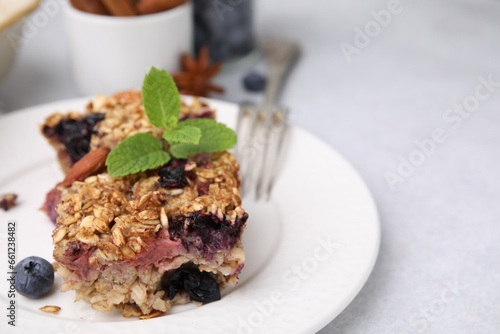 Tasty baked oatmeal with berries on light table  closeup