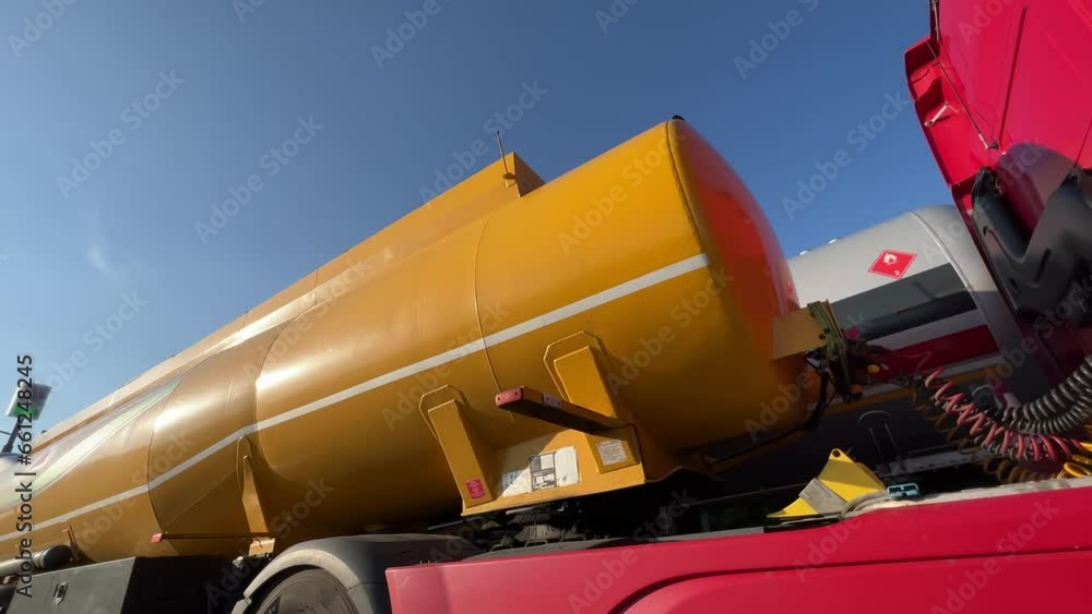 Tanker trucks (Gasoline tanker, gas truck, fuel truck) stand in the parking lot of the oil depot, waiting for the tank to be filled and the subsequent delivery of fuel to the gas station. Wide angle Tanker trucks (Gasoline tanker, gas truck, fuel truck) stand in the parking lot of the oil depot, waiting for the tank to be filled and the subsequent delivery of fuel to the gas station. Wide angle