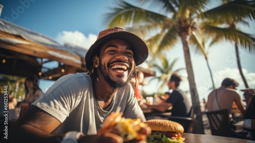 A happy man eating a burger in an outdoor restaurant as a Breakfast