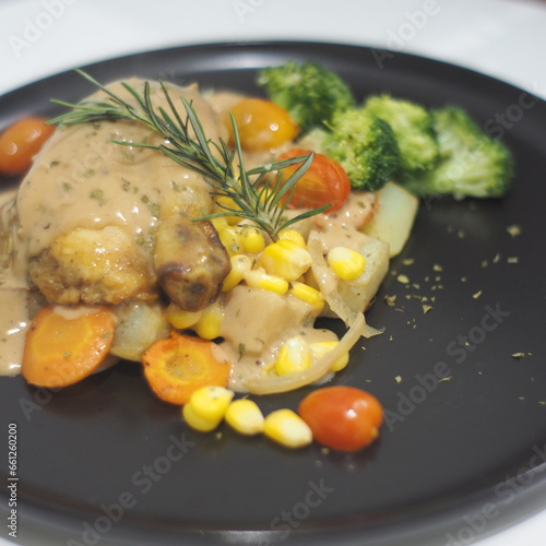 Succulent roasted chicken, baked potatoes, mushroom sauce, and corn on a plate