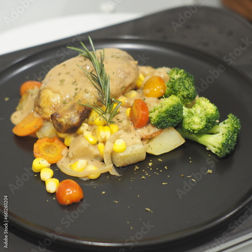 Succulent roasted chicken, baked potatoes, mushroom sauce, and corn on a plate
