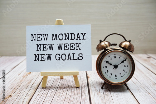New Monday New Week New Goals  word with alarm clock on wooden background