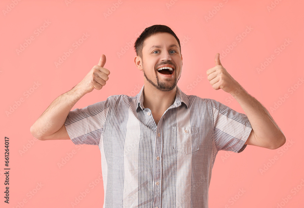 Handsome man in shirt showing thumbs-up on pink background Handsome man in shirt showing thumbs-up on pink background