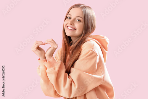Young woman in hoodie makin...
