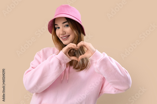 Young woman making heart wi...
