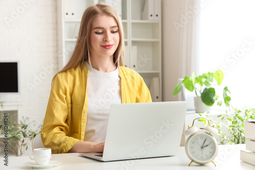 Obraz na plátně Young businesswoman working with laptop at table in office