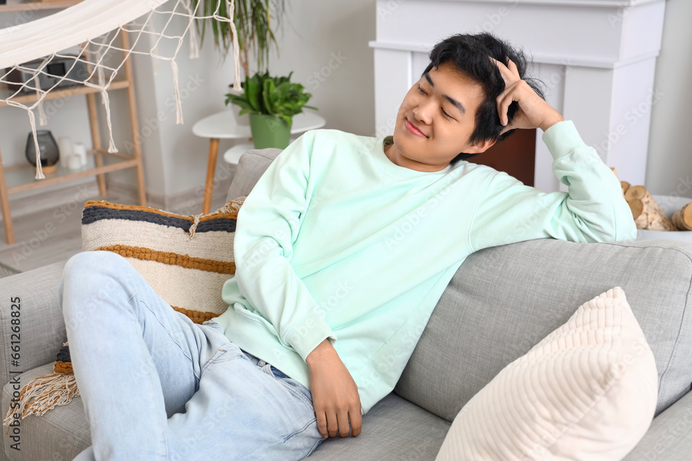 Young Asian man resting on his day off at home Young Asian man resting on his day off at home